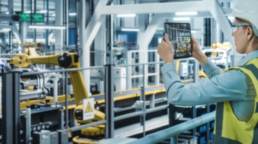 Create a professional image for a blog post about IoT in the workplace. Show a factory worker
